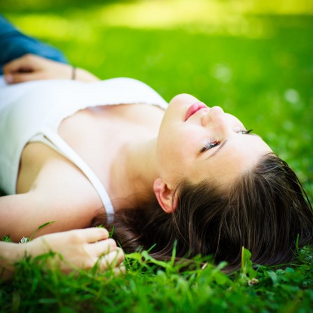 芝生に横たわるナチュラルで魅力的女性