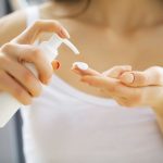 スキンケアクリームを手に出す女性